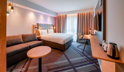 una camera d'albergo con letto e divano di Premier Inn München Airport Süd a Hallbergmoos