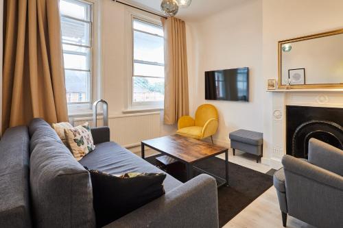 a living room with a couch and a fireplace at Host & Stay - Cosy Twickenham Rugby Gem in Twickenham