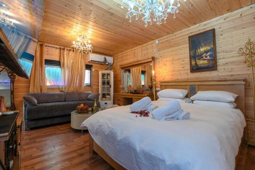 Un dormitorio con una cama grande y una lámpara de araña. en צימר הבקתה, en Tiberíades