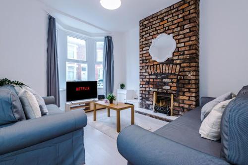 a living room with a couch and a fireplace at Comfy Townhouse - Free parking and Fast Free Wifi in Wallasey