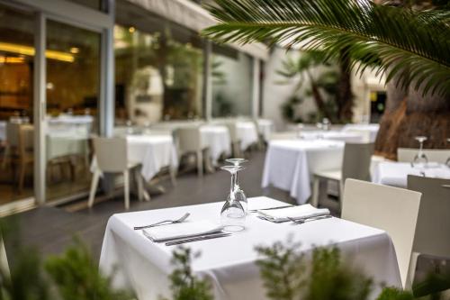 a restaurant with white tables and white chairs and windows at Climia Belroy 4 Sup in Benidorm