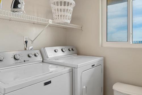 lavadero blanco con lavadora y secadora en 504 Surf Dweller by Alicia Hollis Realtor Rentals - Open March 16th Week, en Fort Walton Beach