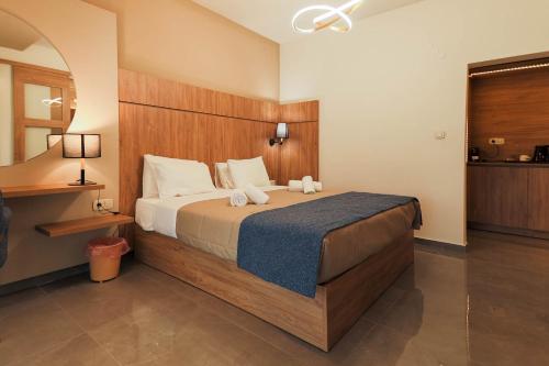 a bedroom with a large bed with a wooden headboard at Tosca Beach Hotel in Paleo Tsifliki