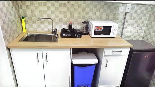 a kitchen counter with a sink and a microwave at شقة السلمة أم القيوين in Umm Al Quwain