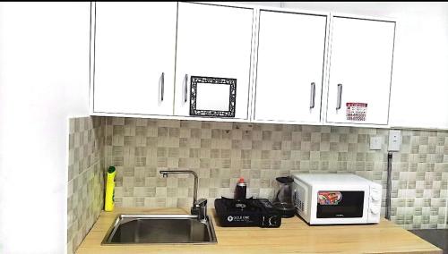 a kitchen counter with a microwave and a sink at شقة السلمة أم القيوين in Umm Al Quwain