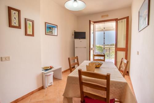 una cucina e una sala da pranzo con tavolo e sedie di Oasi di Cala Pisana a Lampedusa