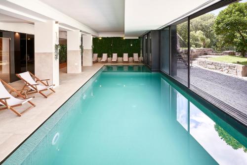 a swimming pool with blue water in a house at Ribeira Collection Hotel by Piamonte Hotels in Arcos de Valdevez
