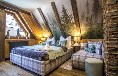 a bedroom with a bed with a dog laying on it at Brzozowa Osada - Premium Chalets Zakopane in Zakopane