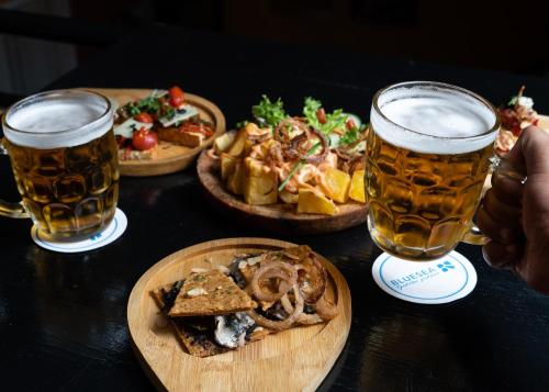 a table with three plates of food and two glasses of beer at Blue Sea Le Printemps in Marrakech