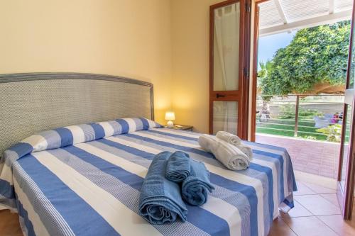 1 dormitorio con 1 cama con toallas en Oasi di Cala Pisana, en Lampedusa