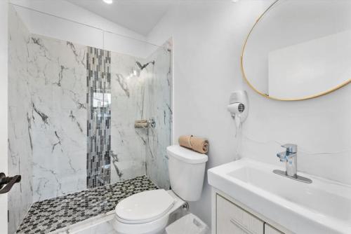 a bathroom with a toilet and a sink and a mirror at Brand New on the Streetcar line in Cincinnati