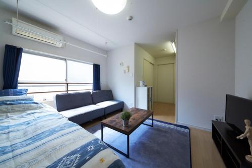 a living room with a bed and a couch at Oyado Kinokuniya Daikokumachi in Nagasaki