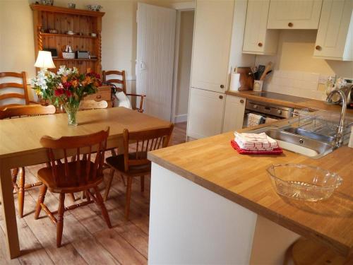 a kitchen with a counter and a table with chairs at Bogroy in Aberlour