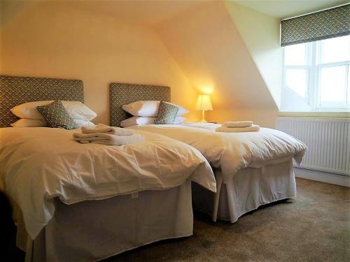 two twin beds in a room with a window at Bogroy in Aberlour