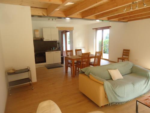 un salon avec un canapé et une table avec des chaises dans l'établissement cottage pleine nature, à Wattwiller