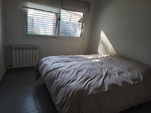 um quarto branco com uma cama e 2 janelas em Casa en Los Caminos del Vino - Chacras de Coria em Vistalba