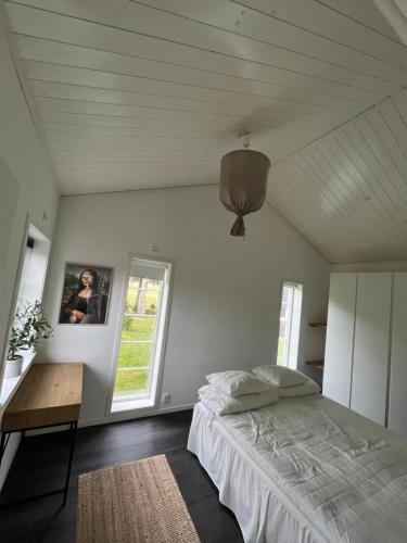 1 dormitorio con cama, mesa y ventana en Fjällbacka Villa, en Fjällbacka