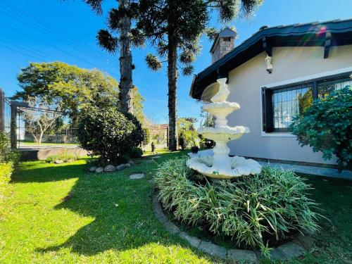 une fontaine blanche dans la cour d'une maison dans l'établissement Residencial Pine House, à Canela