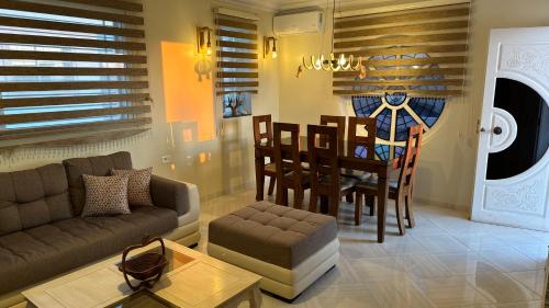 Villa Zembretta في الهوارية: غرفة معيشة مع أريكة وغرفة طعام