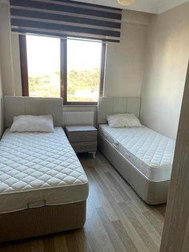 two beds in a room with two windows at BMB GROUP ÇINARCIK HOME 3 in Çınarcık