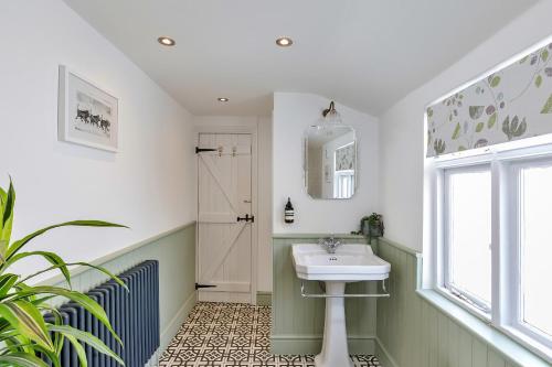 ein Bad mit einem Waschbecken und einem Fenster in der Unterkunft Finest Retreats - Brighton House in Brighton & Hove