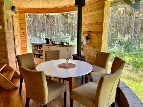 una sala da pranzo con tavolo e sedie in una cabina di Roosa maja parvesaunaga a Reigi