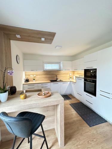 a kitchen with white cabinets and a table and a chair at Resort am Winklfeld 8a in Schwanenstadt