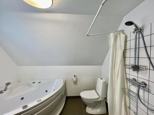 a white bathroom with a tub and a toilet at Large apartment in Lovely Urban Area in CPH Ø in Copenhagen