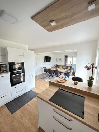 a kitchen with white cabinets and a dining room at Resort am Winklfeld 8a in Schwanenstadt