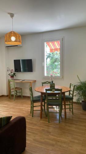 a living room with a table and chairs and a window at Pavillon de l’Étang in Châteauneuf-du-Rhône