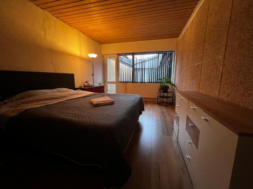 um quarto com uma cama e uma grande janela em Cozy Room in the heart of Rødby! 5km from Femern & Puttgarden! em Rødby