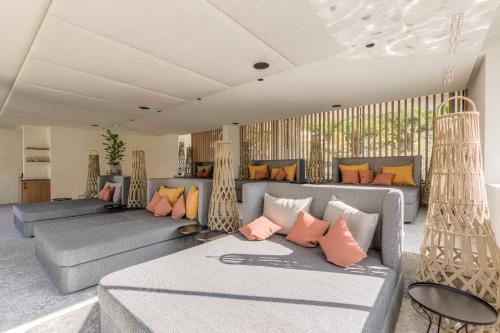 ein Wohnzimmer mit grauen Sofas und orangefarbenen Kissen in der Unterkunft Boutique Hotel AMARIL in Kastelbell