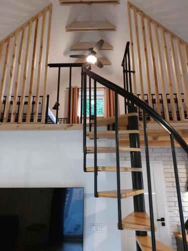 a spiral staircase in a house with a ceiling fan at Leśna Osada in Bystrzyca