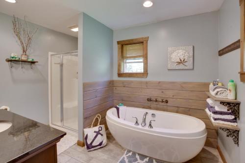 a bathroom with a white tub and a sink at Spacious Cabin with Private Dock on Thompson Lake in Oxford