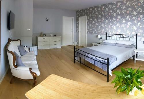 アルバにあるLa casa dei piniのベッドルーム1室(ベッド1台、椅子、ソファ付)