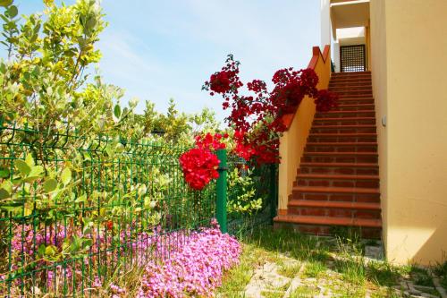 una cerca con flores al lado de una escalera en Roccazzurra, en Nova Siri Marina