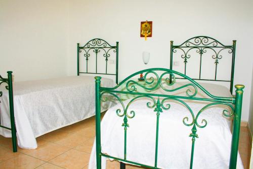 1 dormitorio con 2 camas con sábanas blancas en Roccazzurra, en Nova Siri Marina
