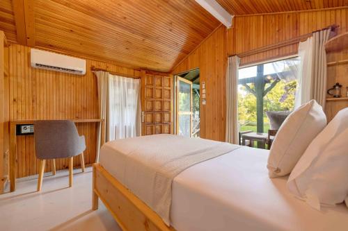 1 dormitorio con cama blanca y ventana en Etenna Beach Bungalows, en Cıralı