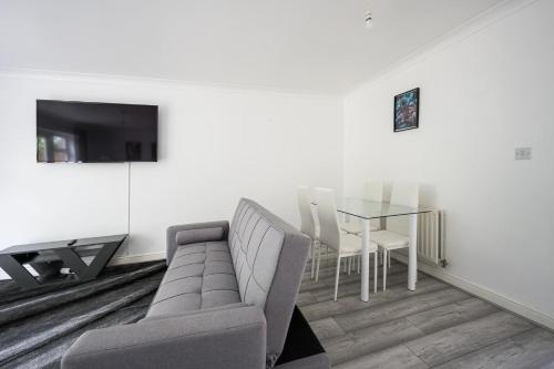 uma sala de estar com um sofá e uma mesa em Maidstone villa 3 bedroom free sports channels,parking em Kent