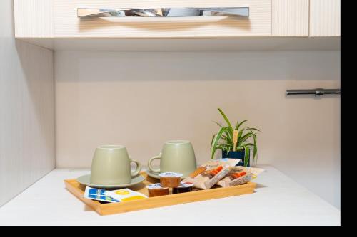 a shelf with two cups and a tray of food at Accogliente intero appartamento in Rome