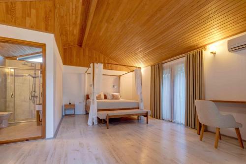 a bedroom with a bed and a bathroom with a shower at Etenna Beach Bungalows in Cıralı