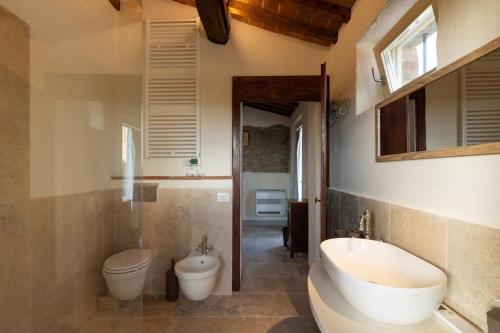 e bagno con vasca, servizi igienici e lavandino. di Villetta Montalla a Cortona