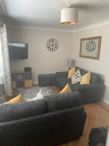 a living room with two couches and a cat sitting on the couch at Seaview in Lossiemouth