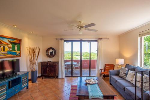 uma sala de estar com um sofá e uma televisão em Boungainvillea 1203 Luxury Apartment - Reserva Conchal em Playa Conchal