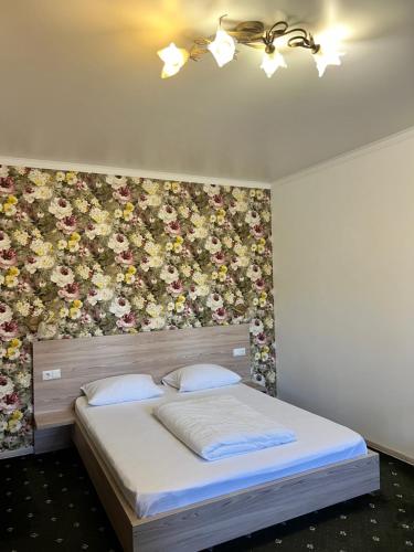 a bedroom with a bed with a floral wall at Vik-Jan in Khmelʼnytsʼkyy