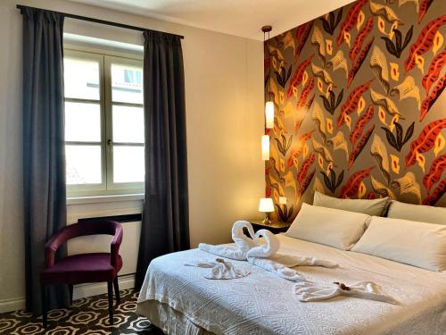 una camera d'albergo con un letto con cigni sopra di Villa Marengo Guest House a Spinetta