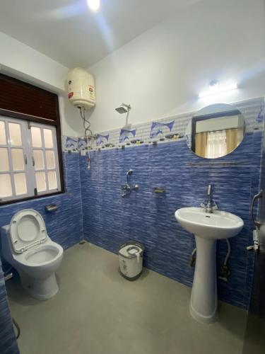 y baño con aseo y lavamanos. en Zongkha Homestay en Gangtok