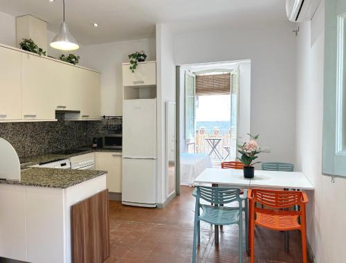 SC Apartamento céntrico con balcón في تيراسا: مطبخ مع طاولة وكراسي ومطبخ مع أجهزة بيضاء