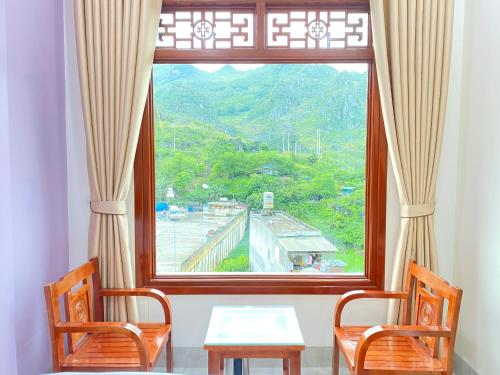 a table and two chairs in front of a window at Van Anh Hotel - Restaurant in Dồng Văn
