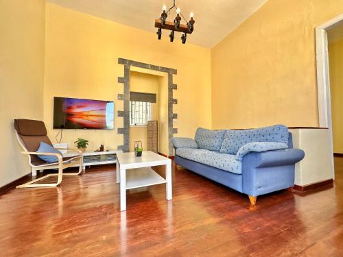 a living room with a blue couch and a table at Casa Tina in Güimar